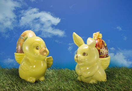 easter duck and bunny on green grass and blue sky as backgroundの写真素材