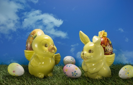 yellow easter duckm and bunny  with green grass and blue skyの写真素材
