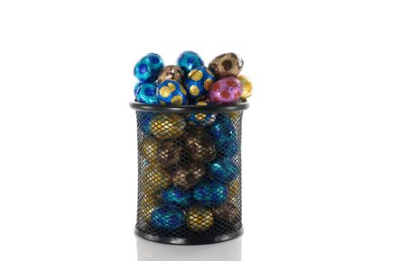 metal container filled with easter eggs in red blue yellow and brownの写真素材