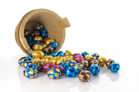 wooden bucket with easter eggs in red blue yellow and pinkの写真素材