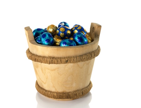 wooden bucket with easter eggs isolated on whiteの写真素材