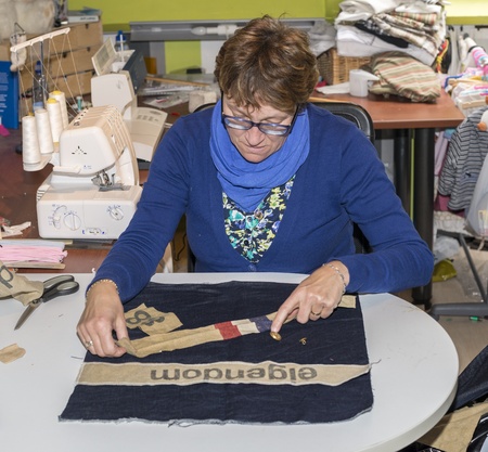 adult woman dressed in blue making clothes in workshopの写真素材