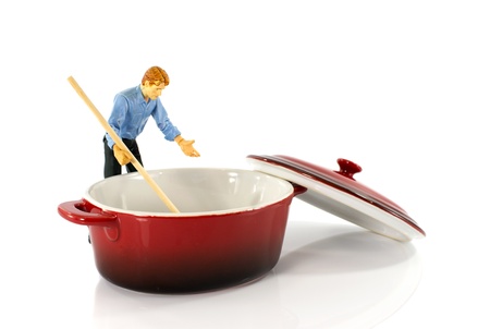 plastic puppet man stirring in red empty saucepanの写真素材