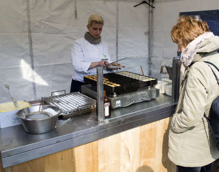 TINTE,HOLLAND - MARCH 30: Woman selling small pancakes on the market in Tinte on March 30, 2013 in Tinte,Holland. This market is only once a year to introduce spring in Tinte.のeditorial素材