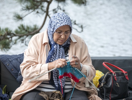 HELLEVOETSLUIS,HOLLAND - JUNE 29 Unidentified woman knitting on a sofa outside,on June 29,2013 in Hellevoetsluis,Holland This days is once a year to introduce art and cultureのeditorial素材
