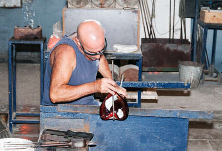 MDINA,MALTA-SEPTEMBERT 29, 2011: Glass blower making glass in hot fire ,on September 29 2011, the glass blowers are showng their profession to tourist and sell the product when finishedのeditorial素材