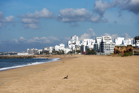 beach and sea in the portugal part Allgarve with the village quarteira as backgroundの写真素材