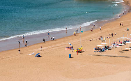 families have fun on the beach in the sand near the waterのeditorial素材