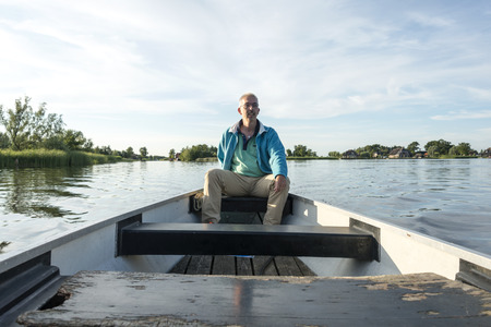 man on wooden boat on lake in the netherlandsのeditorial素材