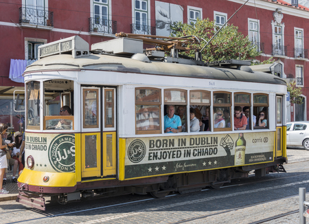 LISBON, PORTUGAL - SEPTEMBER 26: Unidentified people sitting in the Yellow tram  goes by the street of Lisbon city center on September 26, 2015. Lisbon is a capital and must famous city of Portugalのeditorial素材