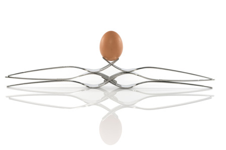 egg balance on six forks isolated on whiteの写真素材