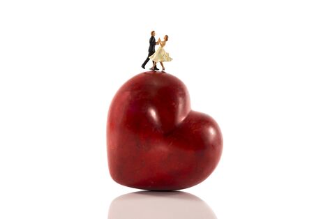 little people wedding couple dancing on red heart shapeの写真素材