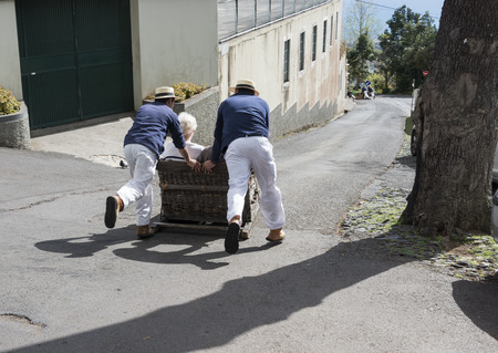 FUNCHAL,PORTUGAL-MARCH 19 Toboggan riders  dive with sledge with tourists on MArch 19, 2016 in Monte- Funchal, Portugal. This is done on public streets and is an old tradition only of this islandのeditorial素材