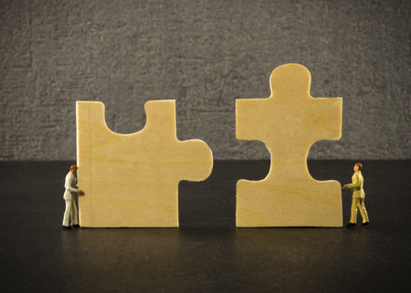 little people solving the problem with the puzzleの写真素材