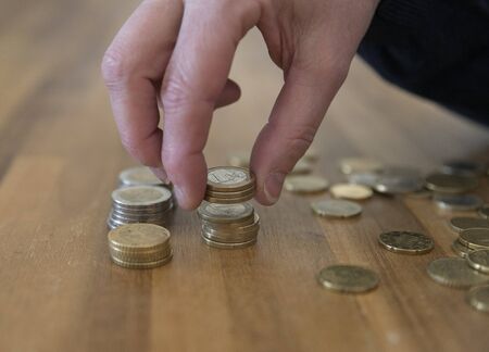 womans hand with euro coins on the table counting the savings