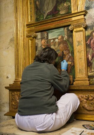 CORDOBA, SPAIN - 04 APRIL, 2017: A woman artist is working on the restoration of a painting in the Mezina Mosque on 04 april 2017, the median , Spain, the Medina houses a catherdral insite the big mosqueのeditorial素材