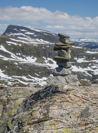 balanced stack of stones at dalsnibba with the mountains and snow as backgroundの写真素材