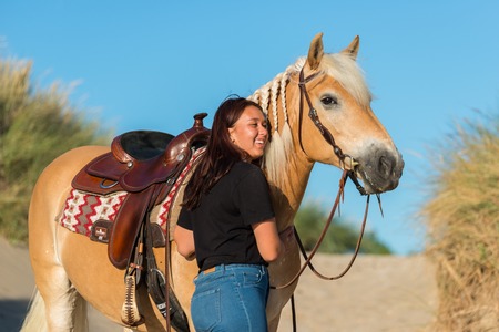 girl with horse posing in the dunesの写真素材
