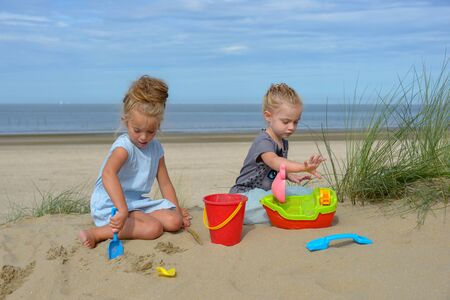 two girls play with toys on the beachのeditorial素材