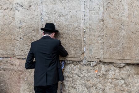 Jerusalem,israel,27-march-2019: Jewish man prays next to a crack filled with letters containing written prayers at the Western Wall in Jerusalem. Israelのeditorial素材
