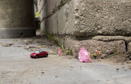 little figure standing on the street with a pink rose for his girl friendの写真素材