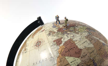 little figures backpaking europea as a big adventure with backpack and walking on a globeの写真素材