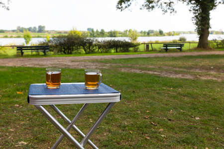 two glasses of tea during afternoon break outside on a table on the river Maasの写真素材