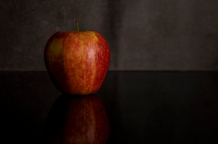 One red apple isolated on black acrylic sheet with reflectionの写真素材
