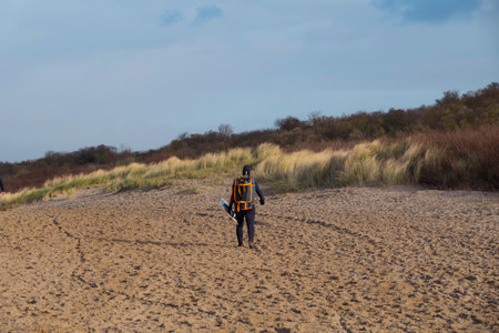 Oostvoorne:Holland,17-jan-2021:Woman with waveboard walking on the beach of oostvoorne, this is a popular palce for watersportsのeditorial素材