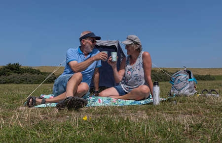 older man and woman with cup of coffe outdoorの写真素材