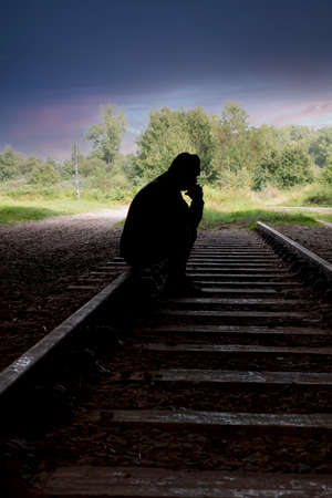 man sitting on a railway trackの写真素材