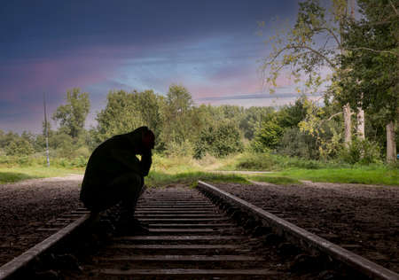 man sitting on a railway trackの写真素材
