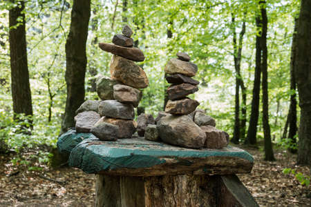 stones stacked in forest with mostly green backgroundの写真素材