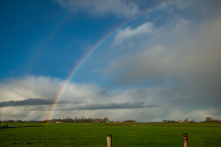 blue sky with rainbow over the fieldsの写真素材