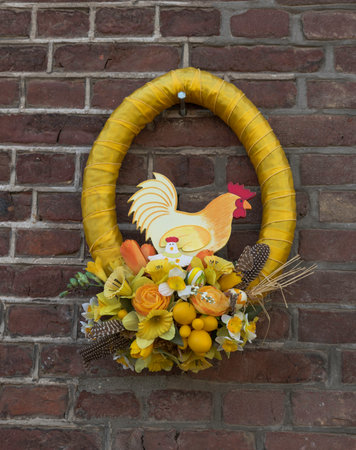 yellow wreath for easter on a wall with easter eggs and flowersの写真素材