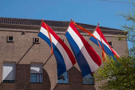 three times a Dutch flag in red white blue with an orange ribbonの写真素材