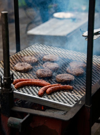 grilling meat on a wood fired barbecue with an open fireの写真素材