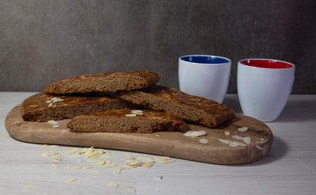 homemade speculaas cake, dSliced homemade almond biscotti displayed on a wooden board, accompanied by two colorful coffee mugs, creating a cozy and inviting atmosphere ideal for coffee breaks.の写真素材