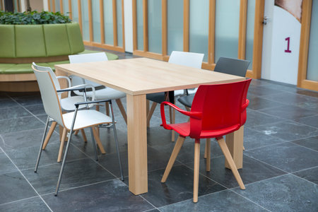 empty waiting room with red white and gray chairs and wooden tablew with papers and tabloidsの写真素材
