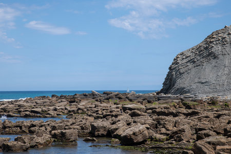 beautifull itzurun beach or zumaia beach in spain in spring with a sailing ship at the horizonの写真素材