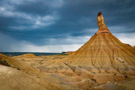 dark clouds and rain as background of the Castildeterra rock formation in the Bardenas Blanca area of the Bardenas Riales Natural Park, Navarre, Spainの写真素材