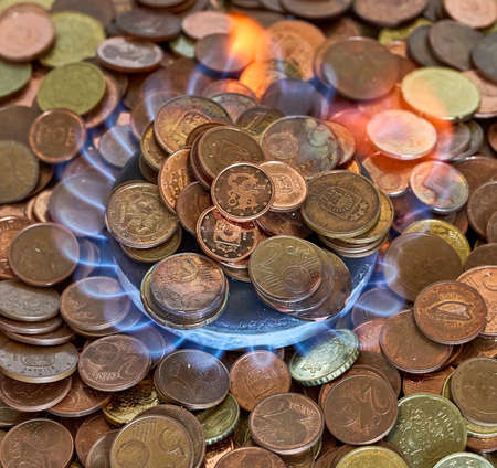 Euro metal coins burning in the gas stoveの写真素材