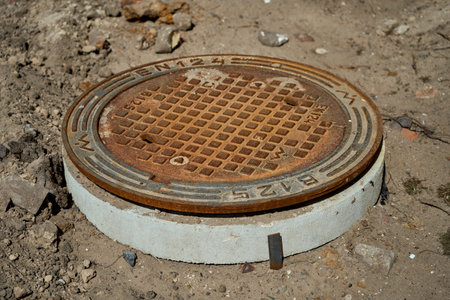 Rusty round sewer hatch on construction site.の写真素材