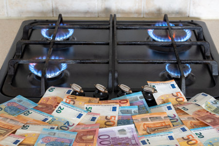 A lot of euro money lying in front of a burning gas stoveの写真素材