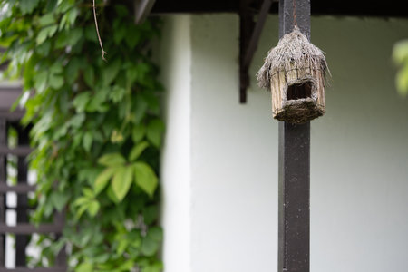 A birdhouse made of branches hanging in the garden.の写真素材