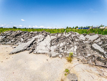 Concrete rubble is carelessly left in a vast field, highlighting significant environmental neglect...