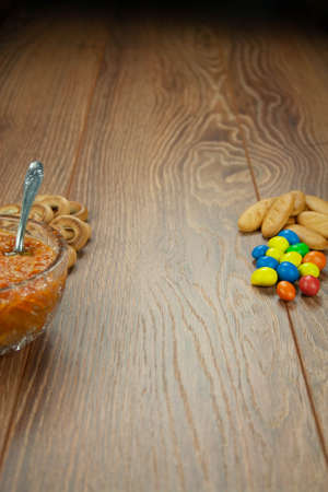Snacks bakery chocolate candies and jam on a wooden tableの写真素材