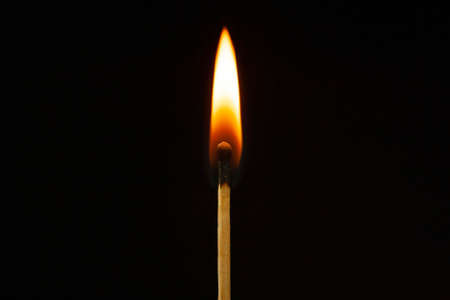 One burning match on the black background isolated side viewの写真素材