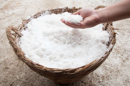 hand with salt in basketの写真素材