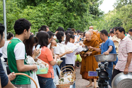UDONTHANI THAILAND - August 10: Buddhist monk walks along a street during alms round on August 10, 2014 at Wat Pa Baan Tat, Udonthani, Thailand.のeditorial素材